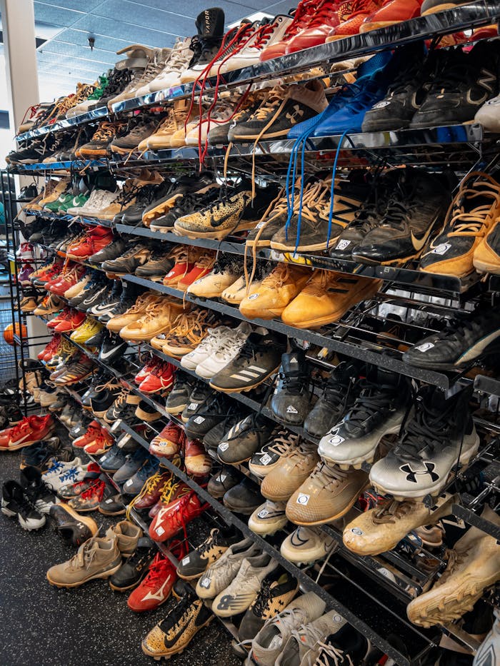 services-06 A wide range of sports shoes displayed on shelves in a retail store, showcasing various brands and styles.